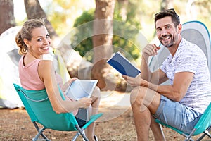 Couple on camping holiay relaxing reading books