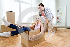 Couple with cardboard boxes having fun at new home