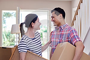 Couple Carrying Boxes Into New Home On Moving Day