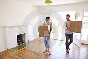 Couple Carrying Boxes Into New Home On Moving Day