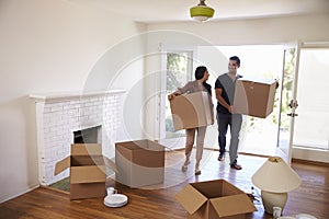 Couple Carrying Boxes Into New Home On Moving Day