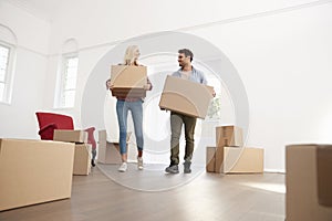 Couple Carrying Boxes Into New Home On Moving Day