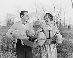 Couple carrying pigs