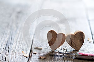 Couple carved wooden hearts and knife abstract love valentines background with free space