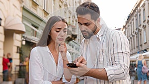 Couple Caucasian man woman using mobile phone smartphone internet maps location tourism trip tour GPS navigation app