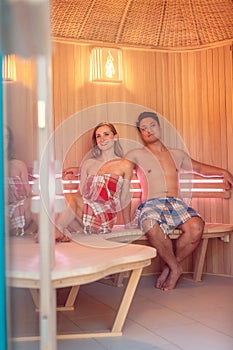 Couple of Caucasian woman and Asian man enjoying the sauna