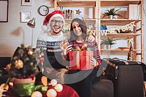 Couple celebrating Christmas at home opens gift