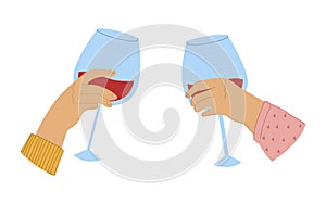 A couple celebrating and drinking red wine. Two hands with wineglasses.