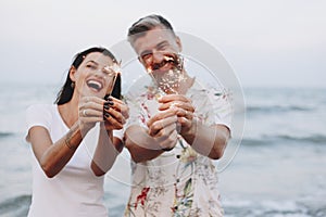 Couple celebrating with sparklers at the beach