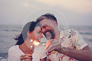 Couple celebrating with sparklers at the beach
