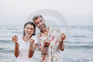 Couple celebrating with sparkles at the beach
