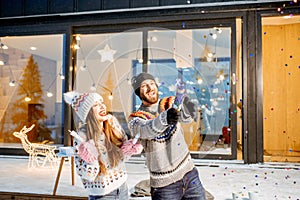 Couple celebrating winter holidays in front of the house outdoors