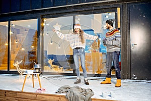 Couple celebrating winter holidays in front of the house outdoors