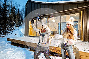 Couple celebrating winter holidays in front of the house outdoors