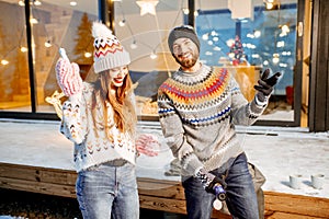 Couple celebrating winter holidays in front of the house outdoors