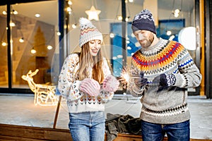 Couple celebrating winter holidays in front of the house outdoors