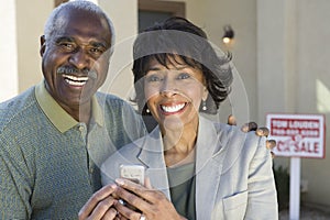 Couple With Cell Phone In Front Of New House