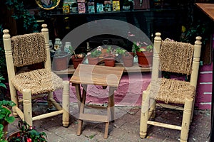 Couple of chairs made of wood and abaca rope with a wooden table in the middle photo