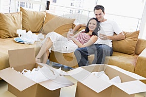 Couple with champagne by boxes in new home