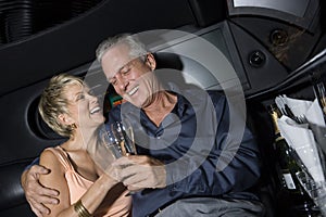 Couple With Champagne Sitting In Limousine