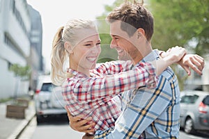 Couple in check shirts and denim hugging each other