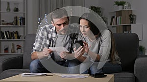 Couple checking receipts on phone at home
