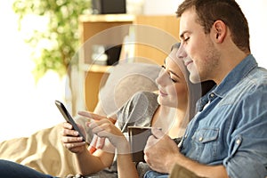 Couple checking a smart phone on a couch