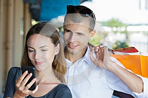 couple checking their bank account online while shopping