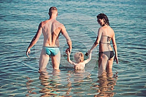 Couple with child enjoying bath time in sea water.