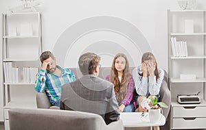 Couple with child teenager discussing problems in family with family psychologist. Parental concept.