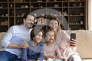 Couple and children looking at cellphone screen making selfie