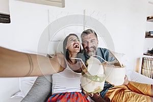 Couple chill on bed drinking coconut juice