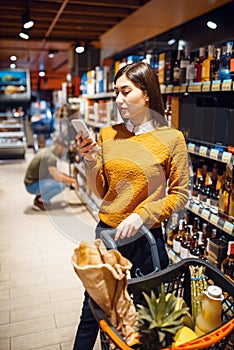 Couple choosing alcohol products in grocery store