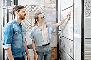 Couple choosing ceramic tiles in the shop