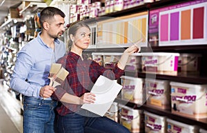 couple is choosing color for paint with brushes