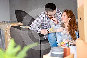 Couple choosing colors for painting home; having fun