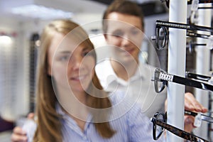 Couple Choosing Glasses In Opticians