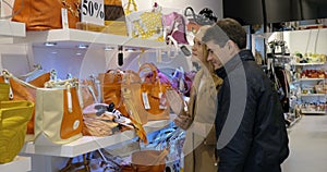 Couple choosing a handbag in the shop