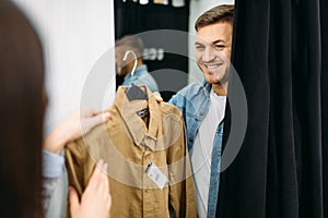 Couple choosing shirts in fitting room, store