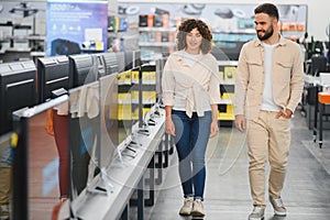 Couple choosing television in electronics store