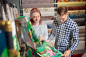 Couple choosing textile at home decoration store, shop. Making of home interior design during quarantine