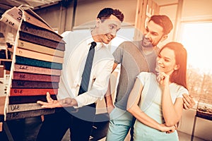 Couple Choosing Upholstery With Furniture Seller.