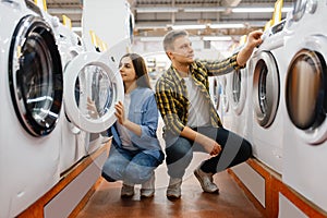 Couple choosing washing machine, electronics store