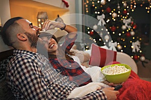 Couple at Christmas eve enjoy with popcorn while watching tv