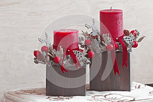 Couple of Christmas floral decorations with red candles
