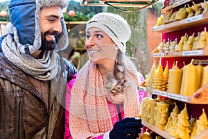 Couple on Christmas market buying candles as present