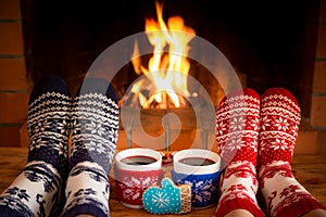 Couple in Christmas socks near fireplace