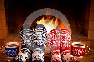 Couple in Christmas socks near fireplace