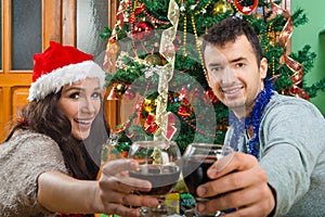 Couple at Christmas time making toast with glasses of wine