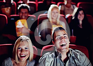 Couple at cinema movie theatre for funny, comic and happy film show in audience auditorium on a date. Smile, relax and